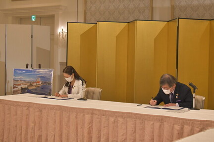 阪急阪神ホールディングス株式会社との包括連携協定締結式の写真（協定書署名の様子）