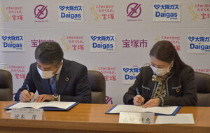 大阪ガス株式会社との包括連携協定締結式の写真（協定書署名の様子）