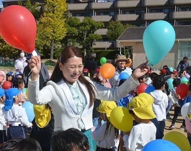 風船をもって子どもたちと笑顔で話す山﨑市長の写真