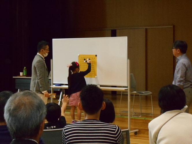 藤原六段対参加者全員での対局を楽しんでいる写真
