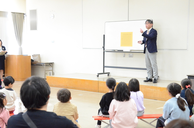 藤原棋士が参加者にルールを教えている写真