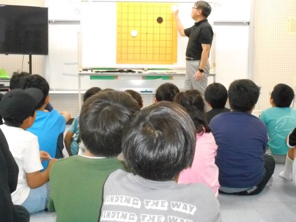 囲碁のルール説明を聞いている子どもたちの写真
