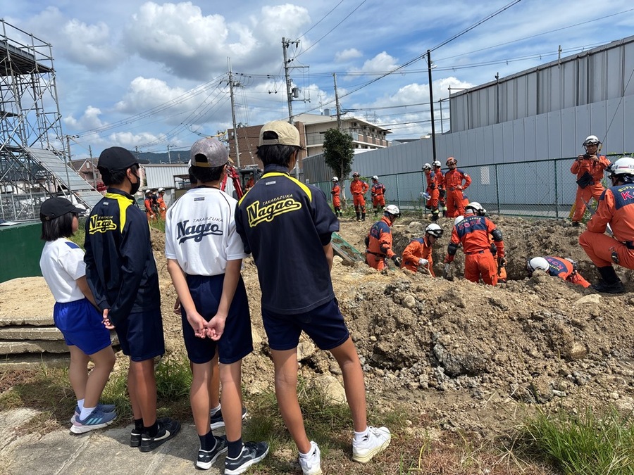 土砂に埋もれた建物を想定して重機等で救助している様子