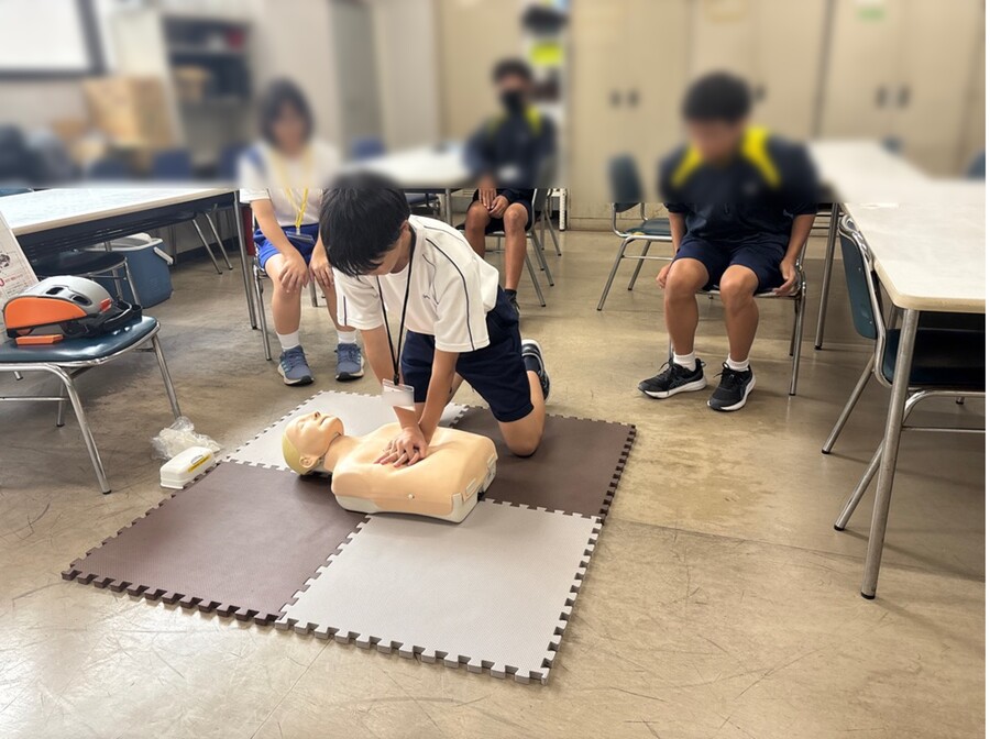救命講習の実技で人形に心肺蘇生法をしている様子