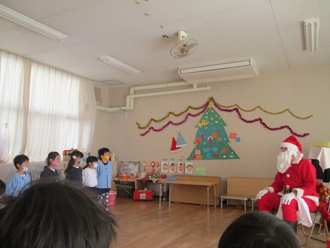 子ども達が、サンタクロースに歌を聞いてもらっている様子の写真