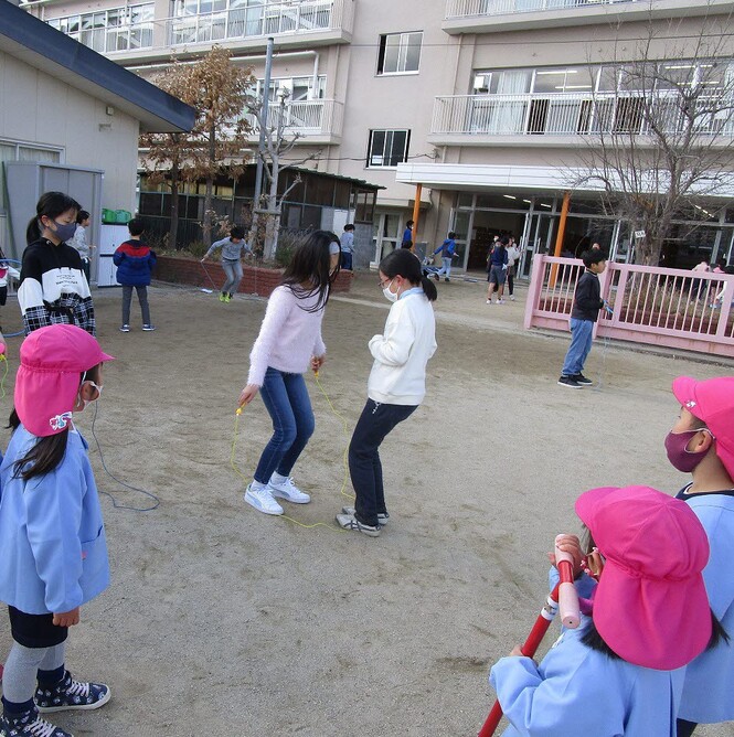 小学生が縄跳びをしているところをみている写真
