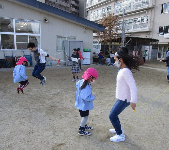 小学生と縄跳びをする写真