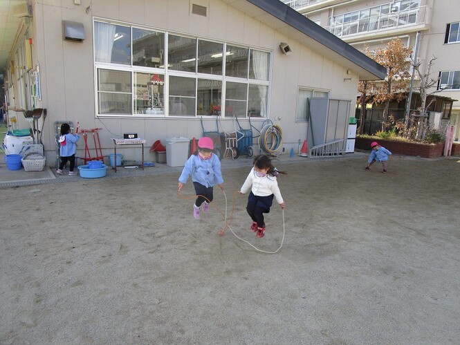 友達と縄跳びをする幼児の写真