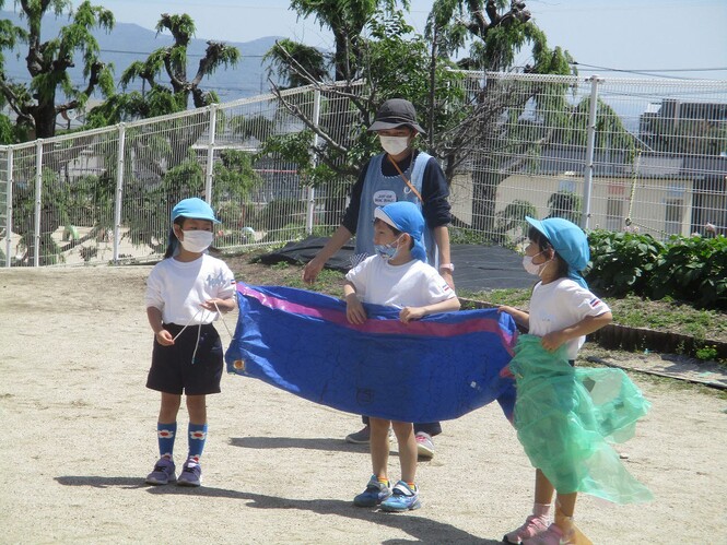 グループの友達と頑張って作ったこいのぼりについて発表している子どもの写真