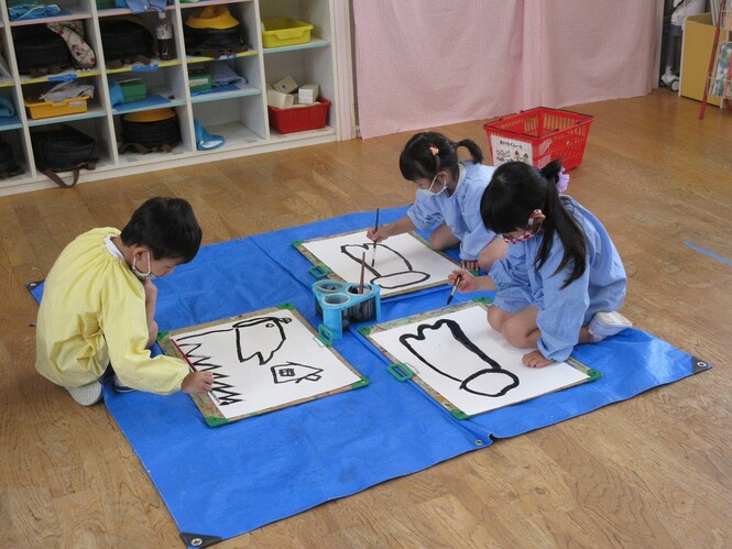 墨でこいのぼりの絵を描く子どもの写真