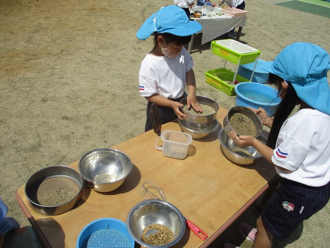 砂をふるいにかけ、さらさらの砂をつくっている子どもの写真