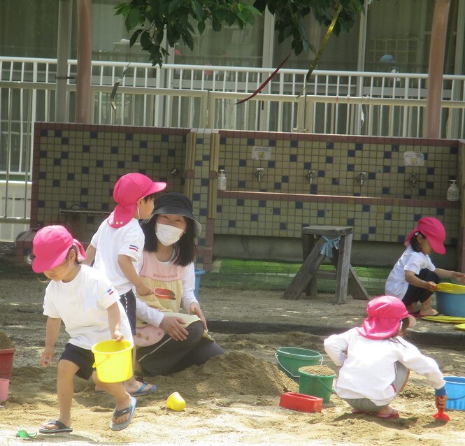 もも組が砂場で山をつくっている写真