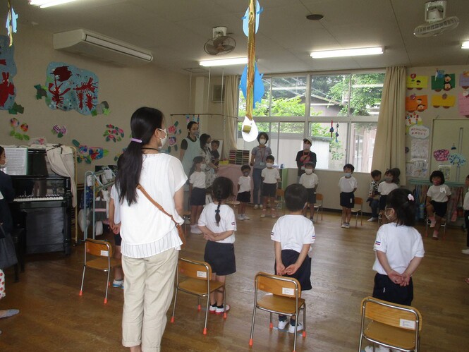 オープンスクールで、歌を歌っているところを保護者にみてもらっている子どもの写真