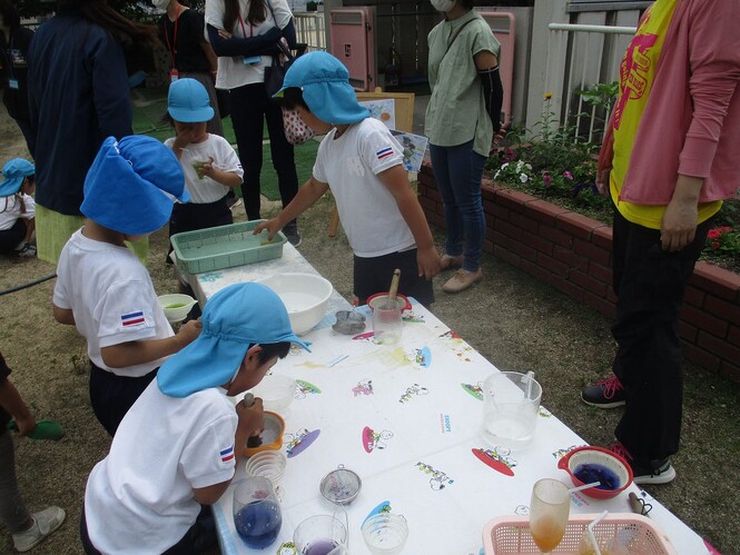 草花で色水を作っている子どもの写真