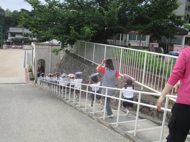 階段をおりて芝生広場に避難していく子どもの写真