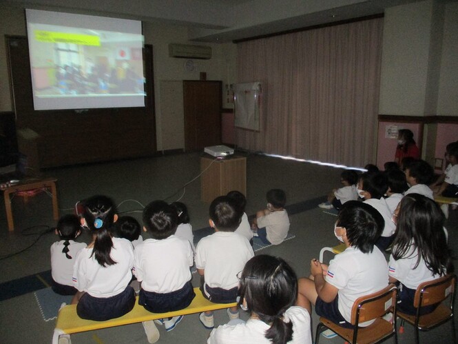 終業式で1学期の様子のスライドショーをみている子どもの写真