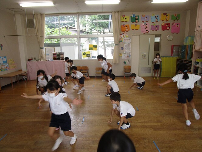 自分がバッタになって遊んでいる子どもたちの写真