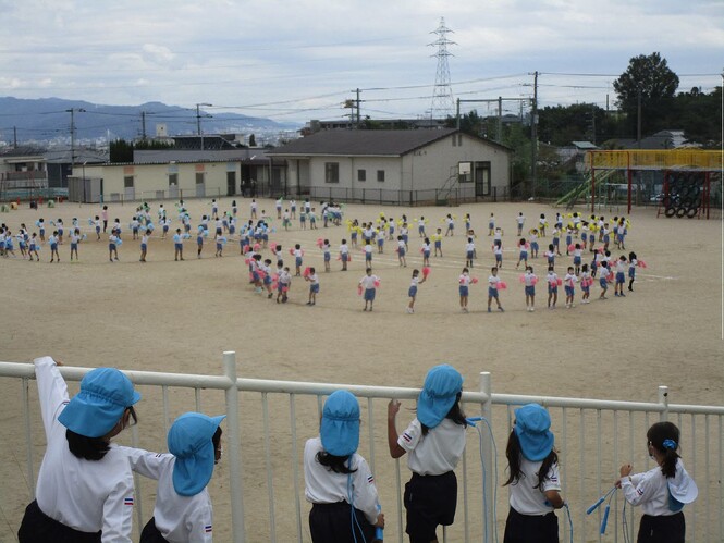 小学生のダンスの様子をみている子どもの写真