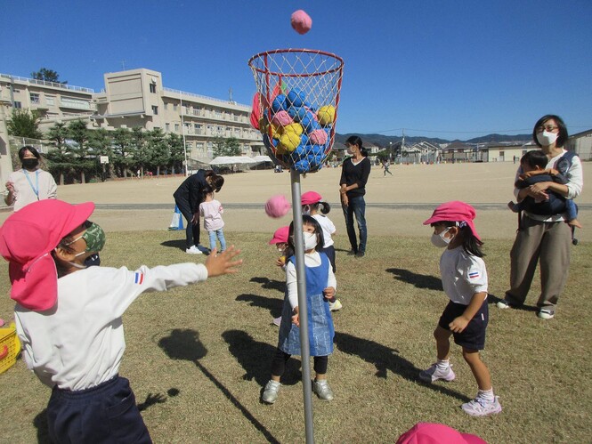 玉入れをしているもも組と未就園児親子の写真