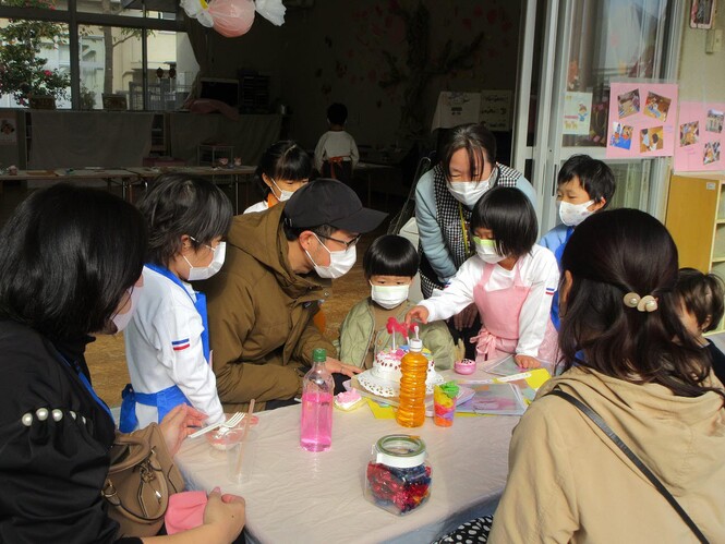 カフェで誕生日祝いをしている子どもと保護者の写真