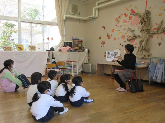 絵本の読み聞かせを聞くもも組子どもたちの写真