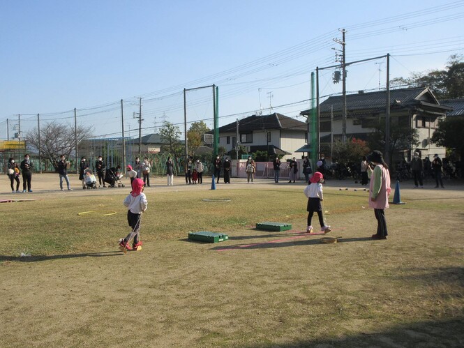 トラックの周りをぱかぽこで歩いてみせるもも組子どもの写真