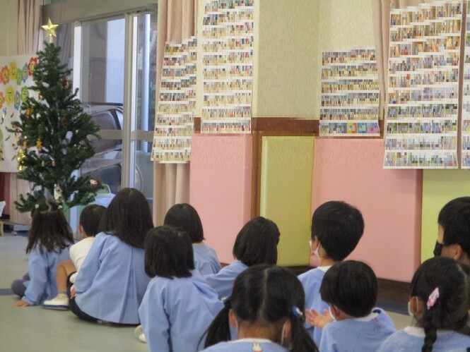 クリスマスツリーに飾りをつけようと順番に並んでいるすみれ組子どもの写真