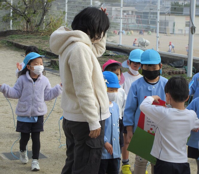 サンタさんからのお手紙をみる先生と子どもたちの写真