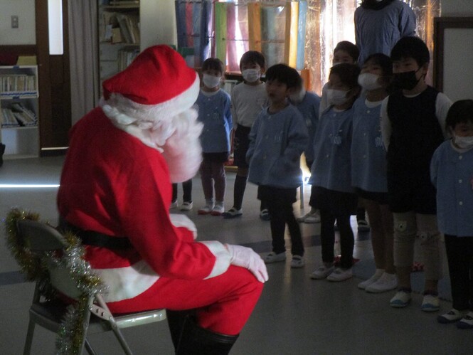 サンタに歌のプレゼントをする子どもたちの写真