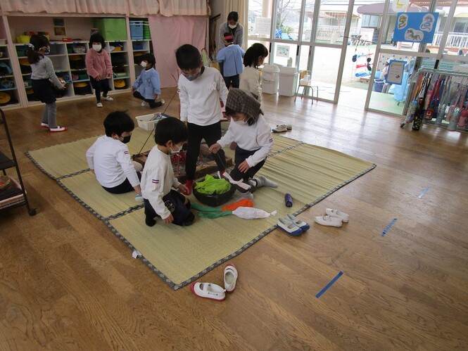 たつのこたろうごっこで、作った囲炉裏でごはんをつくって遊んでいる子どもの写真