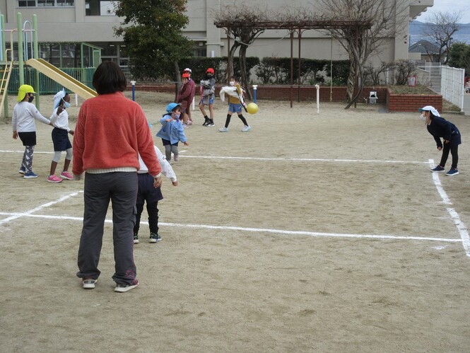 友達の投げるボールからにげる子どもの写真