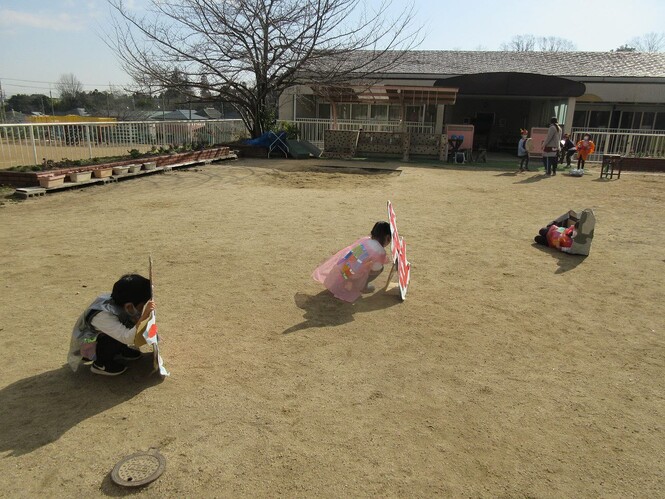 段ボールで作ったサンゴや岩に隠れる子どもの写真