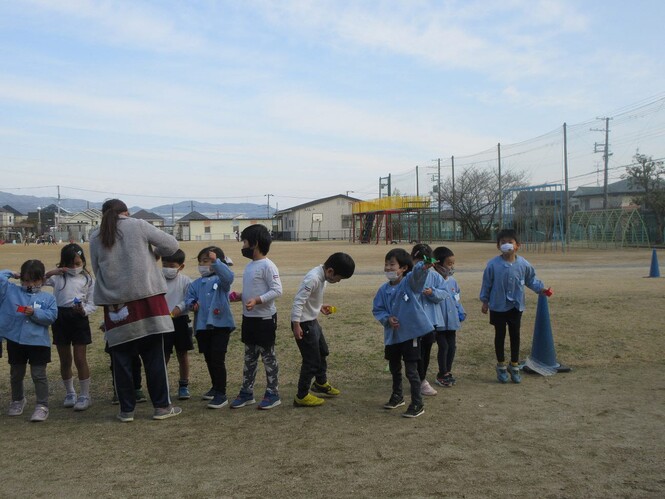 豆まきをしているすみれ組子どもの写真