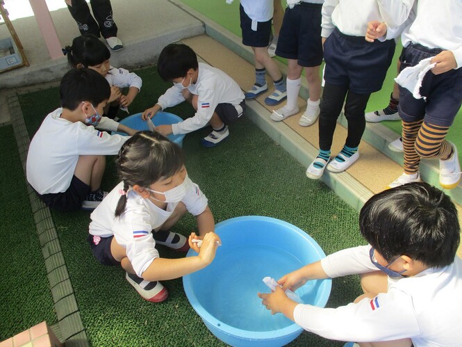 掃除をするために、水で濡らした雑巾を絞っている子どもの写真