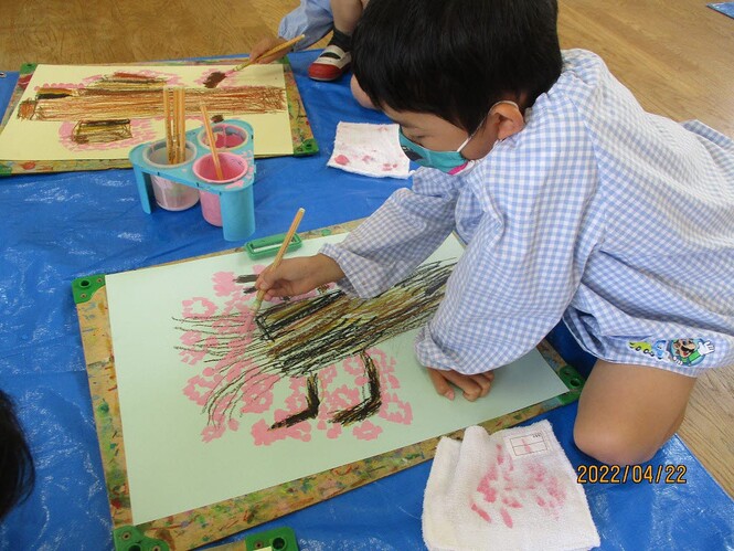 クレパスで桜の花の絵を描いている