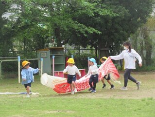 こいのぼりと遊んでいる子どもたちの写真