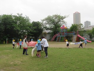 こいのぼりと遊んでいる子どもたちの写真