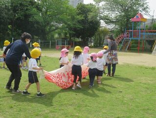 こいのぼりと遊んでいる子どもたちの写真