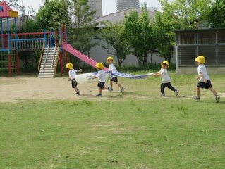 こいのぼりと遊んでいる子どもたちの写真