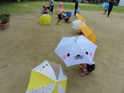 傘にかくれている子どもたちの写真