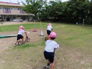 スクーターで走っている子どもたちの写真