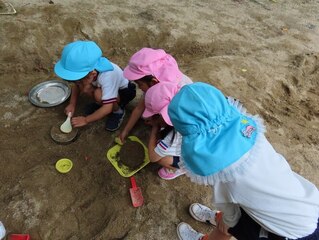 もも組のケーキを見ているすみれ組の子どもの写真