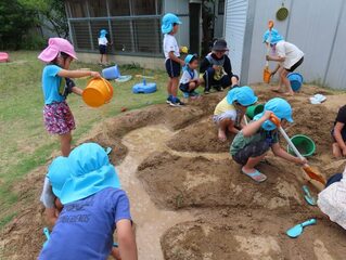 土山で遊んでいる子どもたちの写真