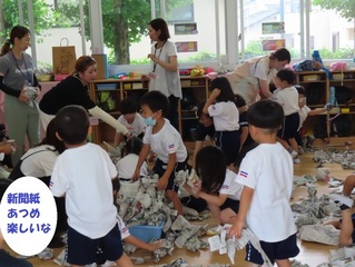 新聞紙で遊んでいる子どもたちの写真