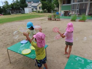 シャボン玉を作っている子どもたちの写真