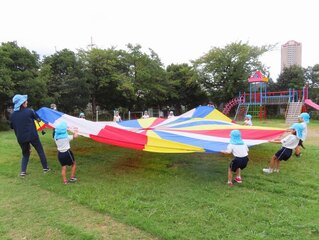 パラバルーンで遊んでいる子どもたちの写真