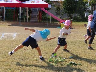 芋のツルで遊んでいる子どもたちの写真