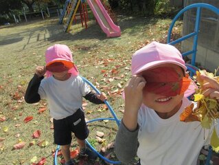 葉っぱで遊んでいる子どもたちの写真