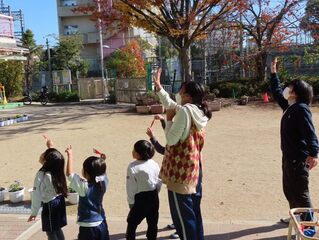 作ったサンタの折り紙を見せている子どもたちの写真