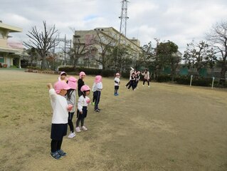 豆をまいている子どもたちの写真